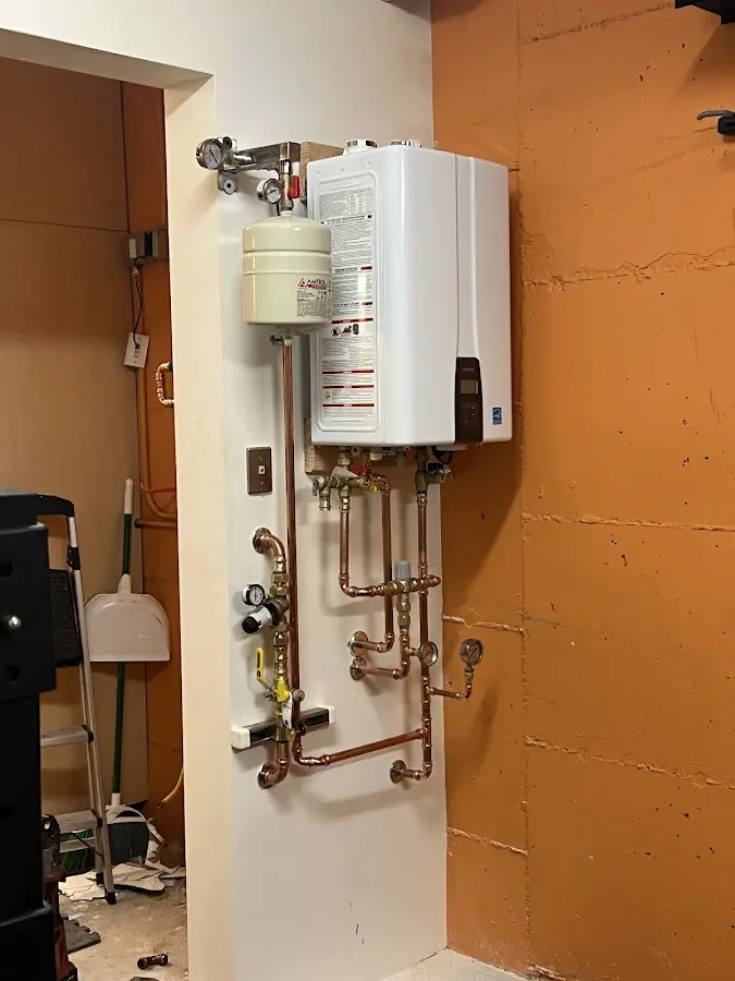 Plumbing technician inspecting water heater connections in Stansbury Park